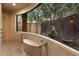 Stunning bathroom features a large window with view of trees, and a built-in bench by shower at 6402 E Chaparral Rd, Paradise Valley, AZ 85253