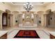 Opulent bathroom with a raised soaking tub, decorative columns, and a grand chandelier creating a luxurious experience at 6402 E Chaparral Rd, Paradise Valley, AZ 85253