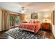 Cozy bedroom featuring a queen-sized bed, hardwood floors, and french doors leading to a balcony at 6402 E Chaparral Rd, Paradise Valley, AZ 85253