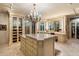 Spacious walk-in closet features display cabinets, a large island dresser, and vanity with mirror at 6402 E Chaparral Rd, Paradise Valley, AZ 85253