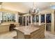 Custom walk-in closet features display cabinets, a large island dresser, and a beautiful chandelier at 6402 E Chaparral Rd, Paradise Valley, AZ 85253