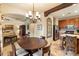 Open dining area with chandelier, wooden table set and views of the kitchen and living room at 6402 E Chaparral Rd, Paradise Valley, AZ 85253