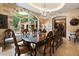 Elegant dining room featuring a large window with fountain view, a stone wall, and a grand chandelier at 6402 E Chaparral Rd, Paradise Valley, AZ 85253