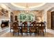 Formal dining room with stone accent wall, fireplace, and large window offering backyard view at 6402 E Chaparral Rd, Paradise Valley, AZ 85253