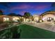 Home exterior featuring landscape lighting, palm trees, large windows, and a circular driveway at 6402 E Chaparral Rd, Paradise Valley, AZ 85253