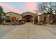 Stunning single-story home with beautiful stone accents, arched entry, and manicured front yard flowerbeds at 6402 E Chaparral Rd, Paradise Valley, AZ 85253