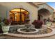 Elegant fountain surrounded by vibrant flowers enhancing the home's entrance with a touch of sophistication and beauty at 6402 E Chaparral Rd, Paradise Valley, AZ 85253