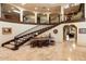 Grand foyer with curved staircase, iron railings, travertine floors, and custom woodwork at 6402 E Chaparral Rd, Paradise Valley, AZ 85253