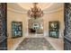 Grand foyer with a large chandelier, decorative cabinets, and elegant rug creates a luxurious entrance at 6402 E Chaparral Rd, Paradise Valley, AZ 85253
