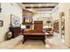 Comfortable living room featuring stone fireplace, wood beams, and a large wooden table at 6402 E Chaparral Rd, Paradise Valley, AZ 85253