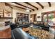 Spacious living room with stone fireplace, beamed ceiling, hardwood floors, and comfortable seating at 6402 E Chaparral Rd, Paradise Valley, AZ 85253