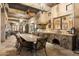 An outdoor kitchen and dining area features stone accents, a built-in grill, and a spacious table for alfresco dining at 6402 E Chaparral Rd, Paradise Valley, AZ 85253