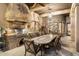 A well-appointed outdoor kitchen features stone accents, a high-end grill, and a chandelier for elegant outdoor dining at 6402 E Chaparral Rd, Paradise Valley, AZ 85253