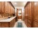 Walk-in pantry featuring ample storage and counter space, custom cabinetry, and stone floors at 6402 E Chaparral Rd, Paradise Valley, AZ 85253
