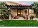 Cozy outdoor patio features a pergola, brick pillars, comfortable seating, and manicured lawn at 6402 E Chaparral Rd, Paradise Valley, AZ 85253