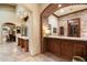 Wet bar with brick archway, wood cabinets, stone counters, and brick accent wall at 6402 E Chaparral Rd, Paradise Valley, AZ 85253