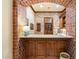 Close-up of a wet bar with brick archway, wood cabinets, stone counters, and brick accent wall at 6402 E Chaparral Rd, Paradise Valley, AZ 85253