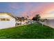 This home boasts a large backyard with mature trees, grass, and an extended covered patio at 6718 N 19Th Pl, Phoenix, AZ 85016