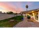 This home features a large, grassy backyard with palm trees, a covered patio, and a block wall at 6718 N 19Th Pl, Phoenix, AZ 85016