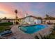 Enjoy the Arizona outdoors in this backyard with a pool, palm trees, and covered patio at 6718 N 19Th Pl, Phoenix, AZ 85016