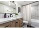 This bathroom features a wood vanity with quartz countertops, a mirror, modern fixtures, and a shower and tub at 6718 N 19Th Pl, Phoenix, AZ 85016