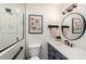Stylish bathroom features a tiled shower, round mirror, and vanity with matte black hardware at 6718 N 19Th Pl, Phoenix, AZ 85016