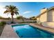 Backyard pool with a palm tree, grass area, lounge chairs, and an umbrella at 6718 N 19Th Pl, Phoenix, AZ 85016