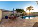 Backyard swimming pool with a patio, dining set, tall privacy wall, and palm tree at 6718 N 19Th Pl, Phoenix, AZ 85016