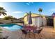 Backyard swimming pool with an outdoor dining set, pool, patio, house, and storage shed at 6718 N 19Th Pl, Phoenix, AZ 85016