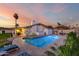 Backyard swimming pool, outdoor dining set, grass area, and white brick home at 6718 N 19Th Pl, Phoenix, AZ 85016