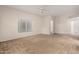 Open living room with neutral carpet, large window, and access to hallways at 7401 W Arrowhead Clubhouse Dr # 1006, Glendale, AZ 85308