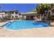 Community pool area featuring a sparkling pool, covered seating, and meticulously landscaped surroundings under a sunny sky at 7401 W Arrowhead Clubhouse Dr # 1006, Glendale, AZ 85308