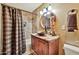 Well-lit bathroom features a vessel sink, stylish mirror, and tiled shower with curtain at 902 W Moon Valley Dr, Phoenix, AZ 85023