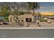 Charming desert home with a Southwestern design, lush trees, and mature landscaping under a vibrant sunset sky at 902 W Moon Valley Dr, Phoenix, AZ 85023