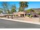 Beautiful home showcases a Southwestern design, mature trees, a brick walkway, and desert landscaping under a clear blue sky at 902 W Moon Valley Dr, Phoenix, AZ 85023