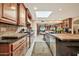 Spacious kitchen featuring wood cabinets, granite counters, and a sun-filled skylight at 902 W Moon Valley Dr, Phoenix, AZ 85023