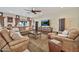 A comfortable living room offers a large TV, cozy seating, stylish fans, and an eye-catching decorative console at 902 W Moon Valley Dr, Phoenix, AZ 85023