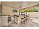 Fully equipped outdoor kitchen with bar seating, built-in grill, sink, and stylish tile flooring at 902 W Moon Valley Dr, Phoenix, AZ 85023