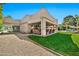 This home features a covered patio with comfortable seating and outdoor television overlooking a landscaped backyard and pool at 902 W Moon Valley Dr, Phoenix, AZ 85023
