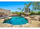 Lush backyard with freeform pool, spa, rock waterfall features, outdoor kitchen, and mature palm trees at 902 W Moon Valley Dr, Phoenix, AZ 85023