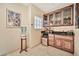 A dry bar with wooden cabinetry, marble countertop, ice maker, and a decorative painting at 902 W Moon Valley Dr, Phoenix, AZ 85023