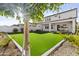 Landscaped backyard with artificial turf and a covered patio with a view of the home at 10150 E Thistle Ave, Mesa, AZ 85212