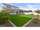 Beautiful backyard with artificial turf, landscaped borders, and a covered patio at 10150 E Thistle Ave, Mesa, AZ 85212
