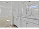 Modern bathroom features a double vanity with white cabinets and a large mirror reflecting a glass-enclosed shower at 10150 E Thistle Ave, Mesa, AZ 85212
