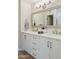 Bathroom featuring double sinks with white cabinets and a large framed mirror at 1021 S Greenfield Rd # 1106, Mesa, AZ 85206