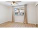 Bright bedroom featuring wood-look floors, neutral walls, window with curtains, and a ceiling fan at 1021 S Greenfield Rd # 1106, Mesa, AZ 85206