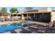 Community pool area featuring lounge chairs, covered seating and clear blue water under a bright sunny sky at 1021 S Greenfield Rd # 1106, Mesa, AZ 85206
