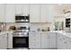 Modern kitchen showcasing white cabinetry, stainless steel appliances, and light-colored countertops at 10634 E Cedar Waxwing Dr, Sun Lakes, AZ 85248