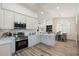 Bright kitchen featuring stainless steel appliances, white cabinets, and hardwood floors and breakfast nook at 10634 E Cedar Waxwing Dr, Sun Lakes, AZ 85248