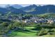 Picturesque aerial view of community nestled among mountains, with golf course, and desert landscape at 10655 N 9Th St # 207, Phoenix, AZ 85020